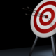 Three arrows accurately striking the bullseye on a target board.