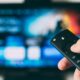 Hand using a streaming TV remote for programmatic CTV advertising
